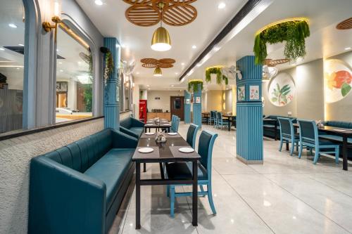 a restaurant with blue booths and a table and chairs at Treebo Kamal Regency in Bhopal