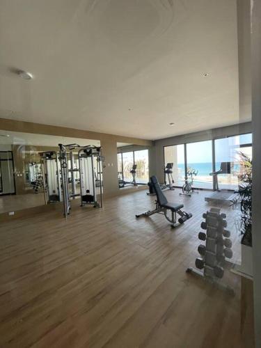a gym with exercise equipment in a large building at New and spacious apartment in Velamar in Altamira