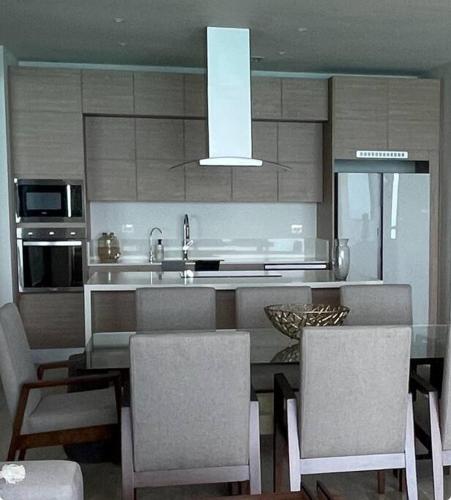 a kitchen with a table and chairs and a sink at New and spacious apartment in Velamar in Altamira