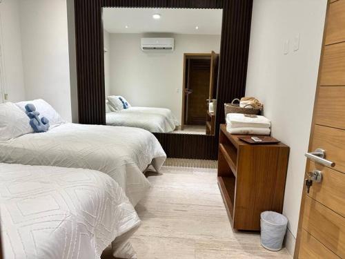 a bedroom with two beds and a mirror at New and spacious apartment in Velamar in Altamira