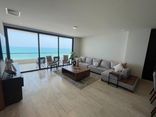 a living room with a couch and a table at New and spacious apartment in Velamar in Altamira
