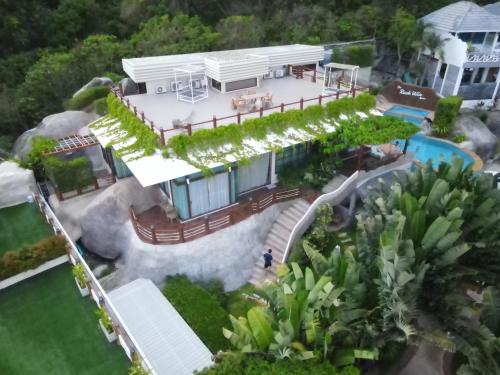 an aerial view of a house with a swimming pool at The Rock Samui Beachfront Villas - Sha Plus Hotel in Lamai
