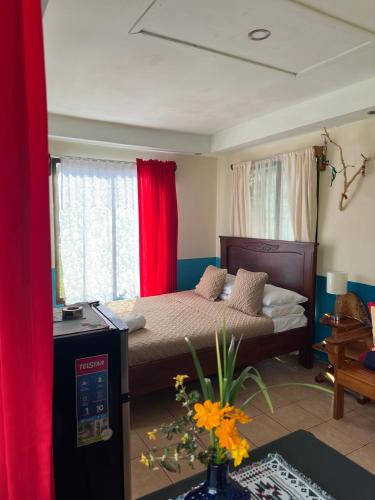 a bedroom with a bed with red curtains at Lidia's Mountain View Vacation Homes in Monteverde Costa Rica