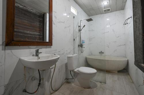 Un baño con lavabo, inodoro y bañera. en Hoki Villa by Urbanview Villa, en Kerobokan
