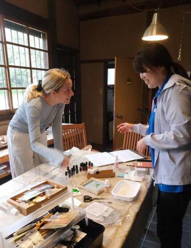 two women standing at a table looking at a table withartifacts at Cochi Stay, for architecture lovers in Nagara