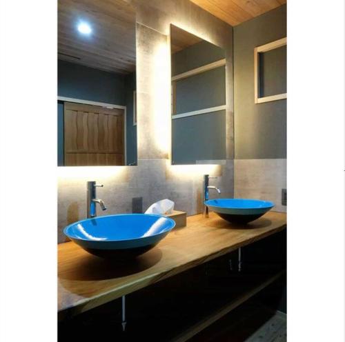 a bathroom with two blue sinks on a wooden counter at Cochi Stay, for architecture lovers in Nagara
