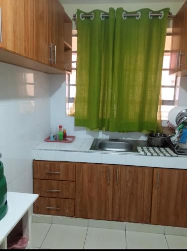 a kitchen with a sink and a green curtain at M - L Homes in Machakos