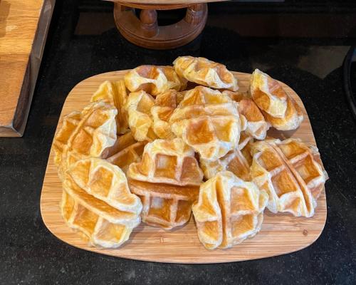 a wooden cutting board with waffles on it at Pingviman Hotel in Chiang Mai