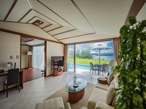 a living room with a couch and a table at Oriental Hills Okinawa in Onna