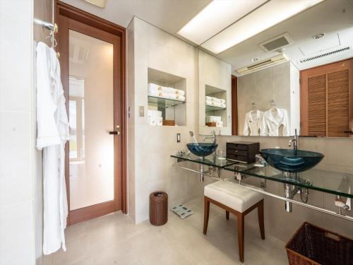 a bathroom with two sinks and a mirror at Oriental Hills Okinawa in Onna