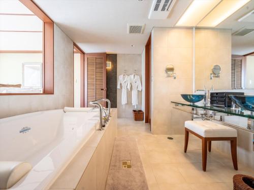 a large bathroom with a tub and a sink at Oriental Hills Okinawa in Onna