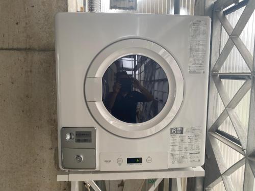 a person taking a picture of a washing machine at ゲストハウスUYokinawa in Uruma