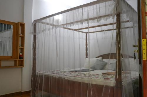 a bedroom with a canopy bed in a room at Villa A & A Hikkaduwa in Hikkaduwa