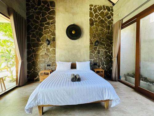 a bedroom with a bed with shoes on it at Cozy room J in Uluwatu near beach,by d'ulu villa in Uluwatu
