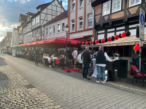 eine Gruppe von Menschen steht mit Tischen auf einer Straße in der Unterkunft Celle Old Town Hideaway in Celle