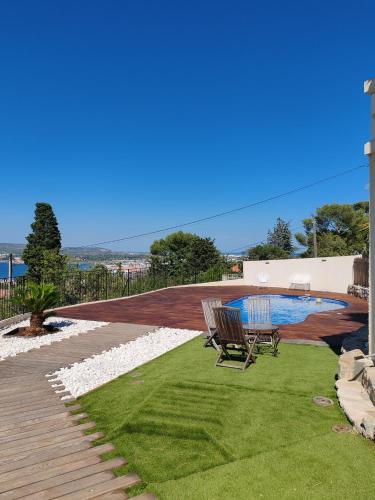 une terrasse avec un banc à côté d'une piscine dans l'établissement L'Occitane bleu, à Sète