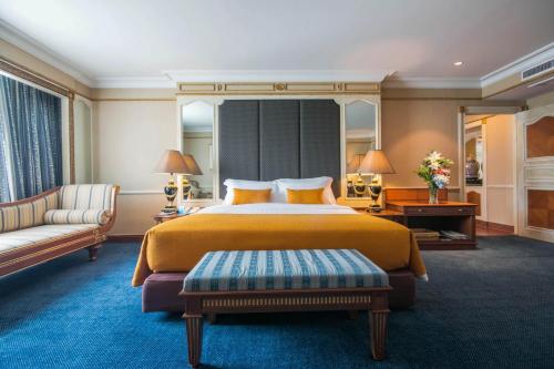 a hotel room with a large bed and a couch at Golden Tulip Sovereign Hotel Bangkok in Bangkok