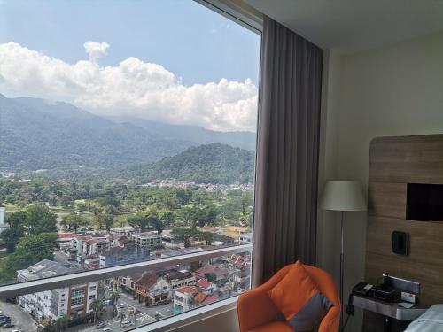 a room with a large window with a view of a city at Novotel Taiping in Taiping