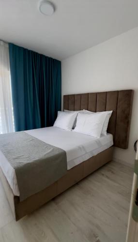 a bedroom with a large bed with a blue curtain at Apartments Sea Side in Petrovac na Moru