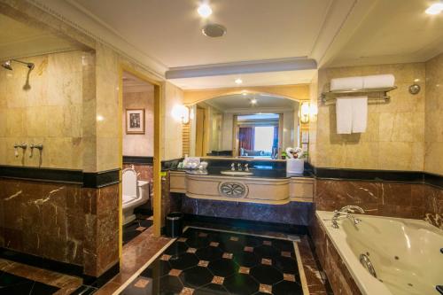a large bathroom with a tub and a sink at Golden Tulip Sovereign Hotel Bangkok in Bangkok