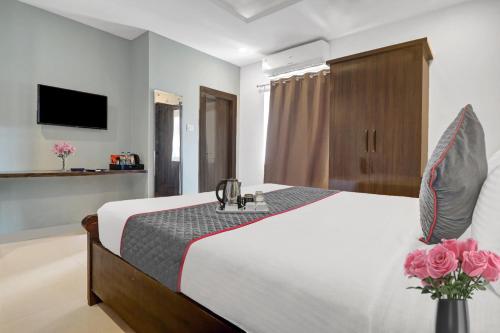 a bedroom with a bed with flowers on it at Super Townhouse RCC PARK VIEW INN in Hyderabad