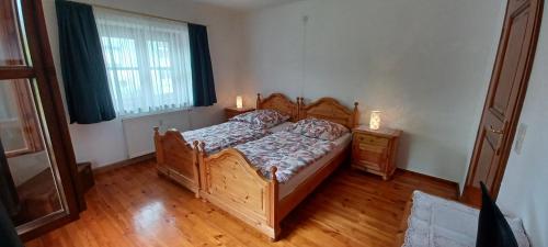 a bedroom with a wooden bed and a window at FEWO Baumburg in Altenmarkt an der Alz