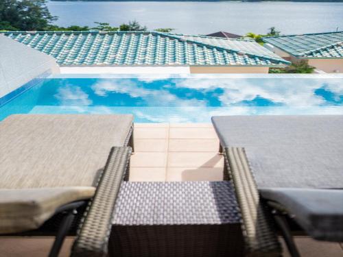 two chairs sitting next to a swimming pool at Oriental Hills Okinawa in Onna