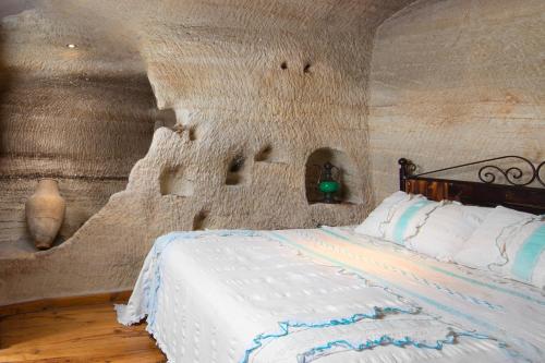 a bedroom with a bed in a room with a wall at Terra Cave Hotel in Goreme