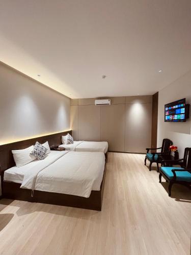 a bedroom with two beds and a flat screen tv at Khách Sạn LUCIEN HOTEL Quy Nhơn in Quy Nhon