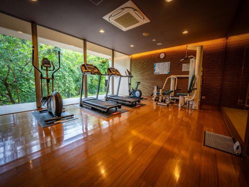 a gym with several treadmills and exercise equipment in a room at Oriental Hills Okinawa in Onna