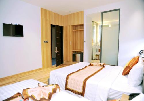 a hotel room with two beds and a mirror at Khách Sạn LUCIEN HOTEL Quy Nhơn in Quy Nhon