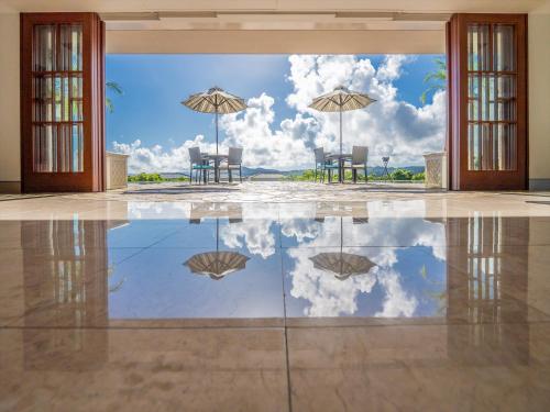 a reflection of two chairs and umbrellas in a room at Oriental Hills Okinawa in Onna