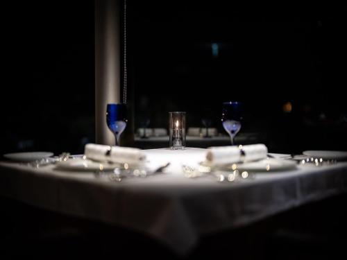 a table with a white table cloth and two wine glasses at Oriental Hills Okinawa in Onna