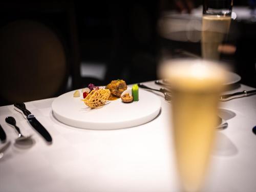 a plate of food on a table with a glass of beer at Oriental Hills Okinawa in Onna