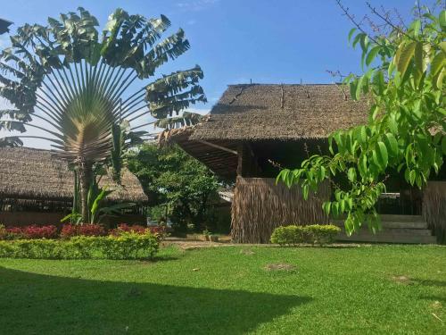 a resort with a palm tree in the yard at Hôtel Framotel Kribi in Kribi