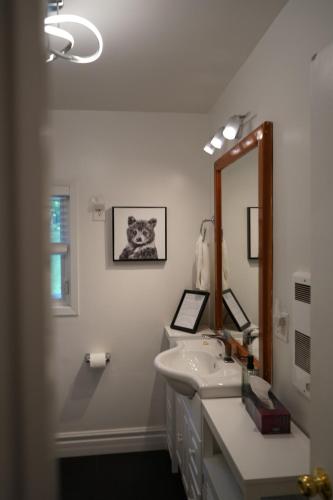 a white bathroom with a sink and a mirror at Mary Lake Sunset Lodge in Port Sydney