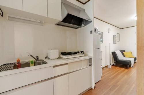 a kitchen with white cabinets and a sink at Abiko Stay in Osaka Namba in Osaka