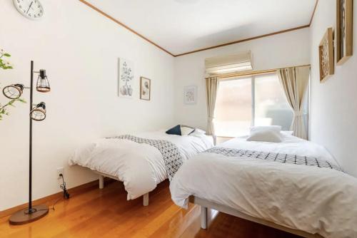 a bedroom with two beds and a window at Abiko Stay in Osaka Namba in Osaka