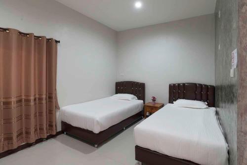two beds in a small room with at Nava Resort in Nakhon Nayok