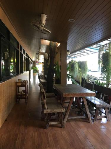 a long wooden table and chairs in a restaurant at Nava Resort in Nakhon Nayok