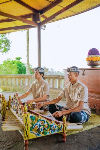 a couple of men sitting on a bench at Bagus Jati Health & Wellbeing Retreat in Tegalalang