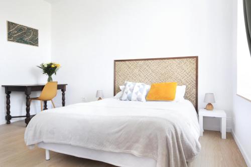 une chambre blanche avec un lit et un bureau dans l'établissement Le logis du Parc-Second Souffle-Cherbourg, à Cherbourg en Cotentin