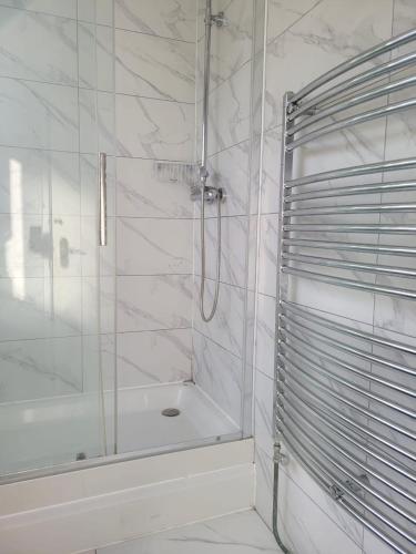 a white bathroom with a shower and a tub at Abakwa Red in Kingsthorpe