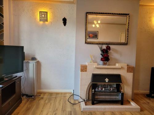 a living room with a fireplace and a mirror at Abakwa Red in Kingsthorpe