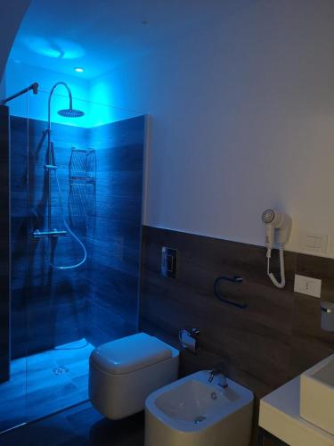 a bathroom with a shower and a toilet and a sink at Luxmarì Hotel & Spa in Castellammare del Golfo