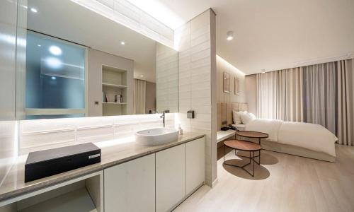 浦项Pohang Hotel Noblion的带水槽和床的浴室