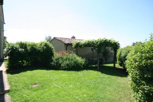 a yard with a bench and some bushes at Podere Il Pino in Poggibonsi