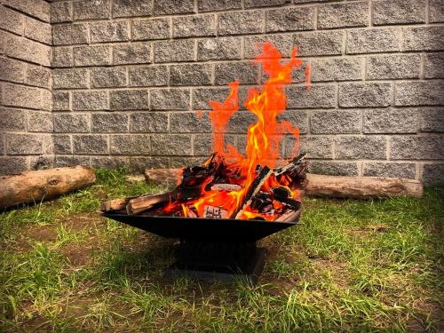 a fire pit sitting in the grass next to a brick wall at Bedroom La Casa Dilijan N1 in Dilijan