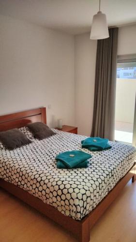 a bedroom with a bed with two green bags on it at Bela Baia Holiday in Salir de Porto