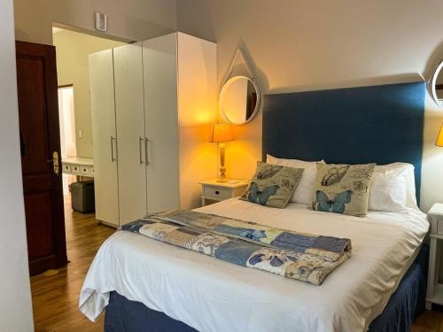 a bedroom with a large bed with a blue headboard at Telestai Guest House in White River